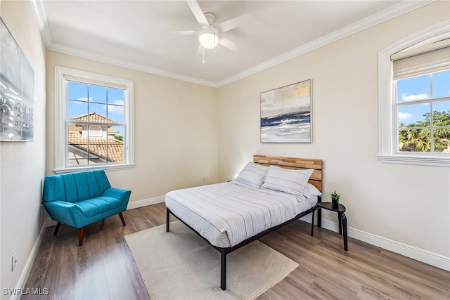 bedroom featuring hardwood / wood-style floors, ceiling fan, and ornamental molding