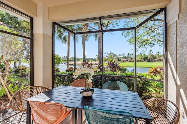 sunroom featuring a water view