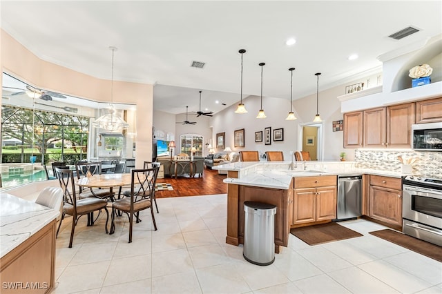 kitchen featuring hanging light fixtures, stainless steel appliances, kitchen peninsula, and ceiling fan