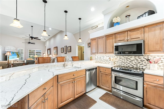 kitchen featuring pendant lighting, sink, ceiling fan, light stone countertops, and stainless steel appliances