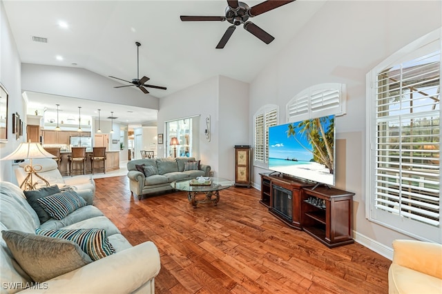 living room with hardwood / wood-style flooring, high vaulted ceiling, and ceiling fan