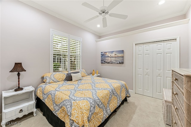 bedroom with crown molding, ceiling fan, a closet, and light carpet