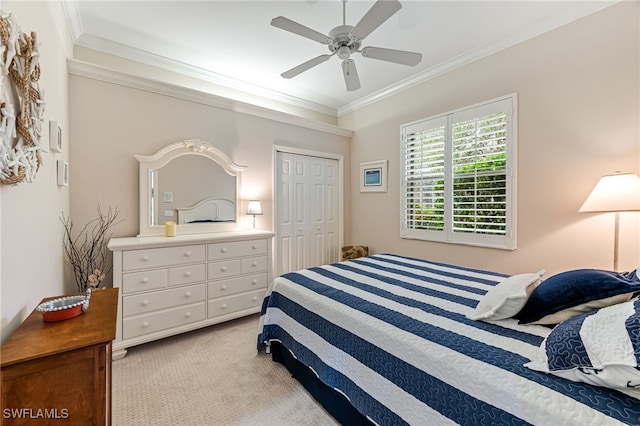 bedroom featuring ceiling fan, light colored carpet, crown molding, and a closet