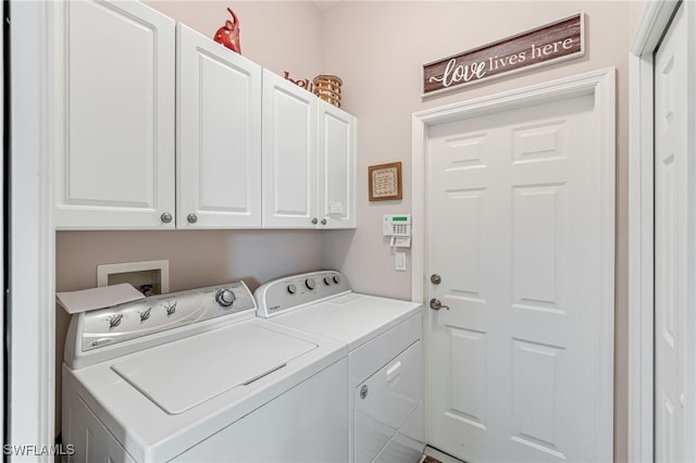 washroom with washer and dryer and cabinets