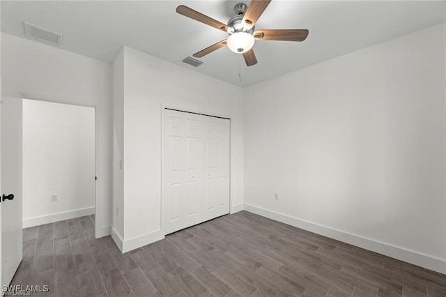 unfurnished bedroom featuring ceiling fan, dark wood-type flooring, and a closet