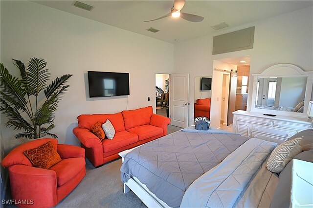 bedroom featuring ceiling fan, a barn door, and light colored carpet