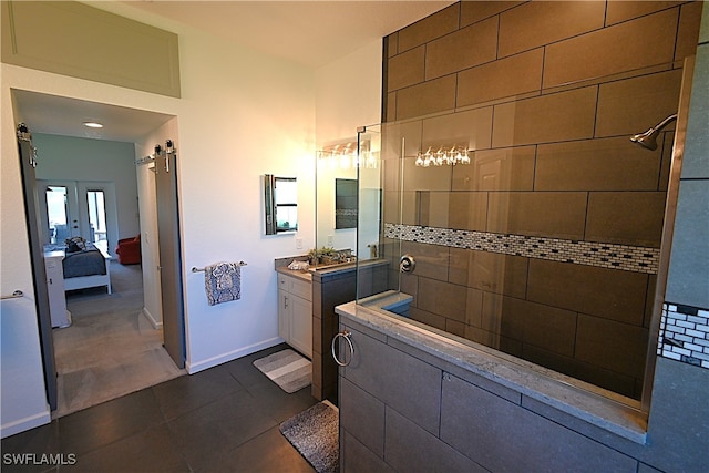 bathroom with tile patterned flooring, a tile shower, and vanity