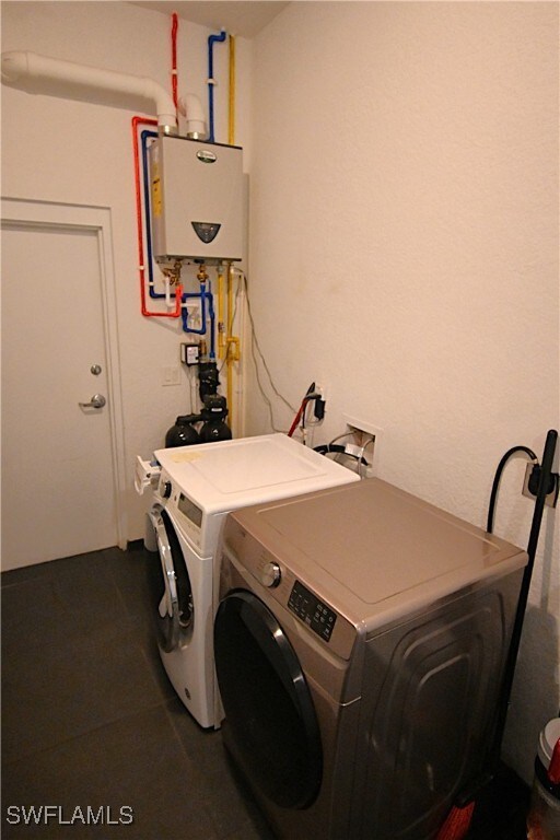 laundry area featuring washer and clothes dryer and tankless water heater