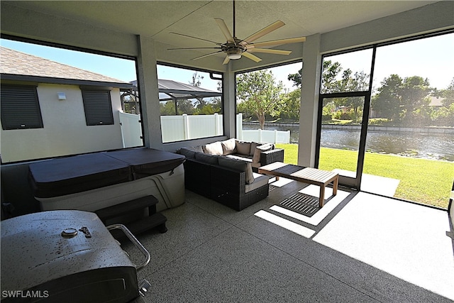 sunroom with a water view and ceiling fan