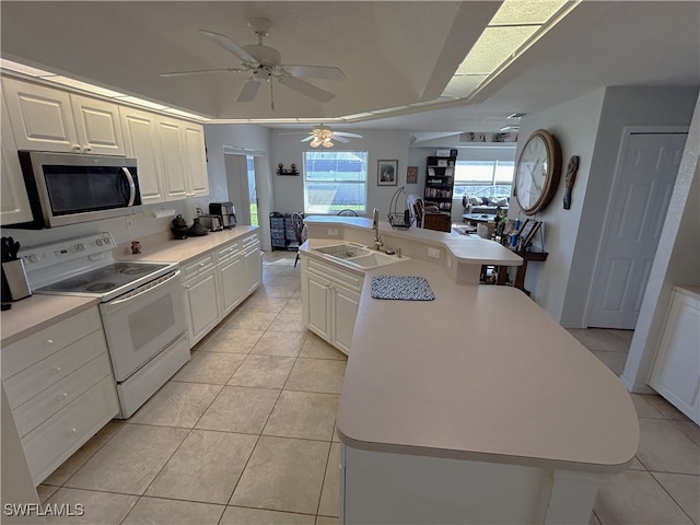 kitchen with a kitchen island with sink, sink, white cabinets, and white electric range oven