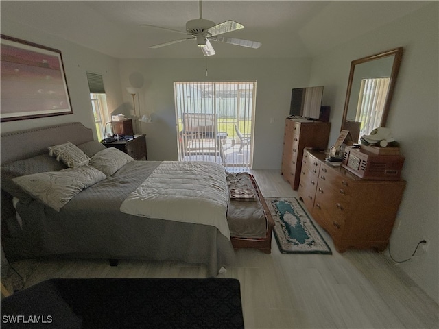 bedroom with ceiling fan, light hardwood / wood-style floors, and vaulted ceiling