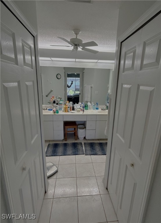 bathroom featuring tile patterned floors, ceiling fan, vanity, and a textured ceiling