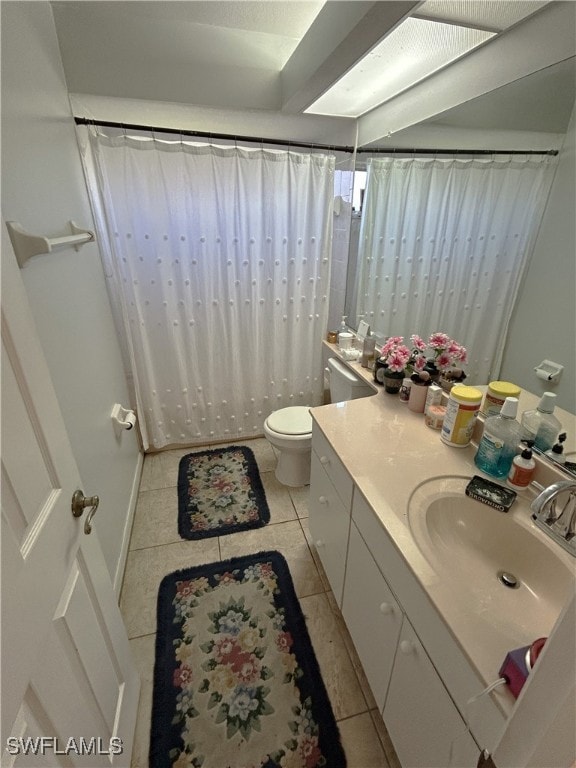 bathroom with tile patterned flooring, vanity, and toilet