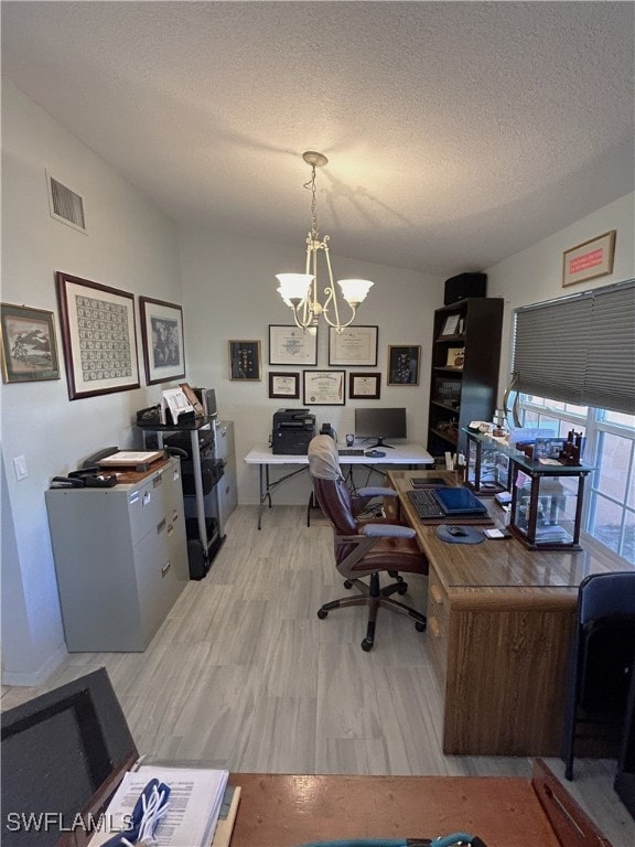 office space with a chandelier, a textured ceiling, and light hardwood / wood-style floors