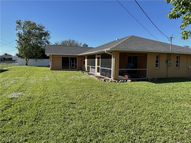 rear view of property with a sunroom and a yard