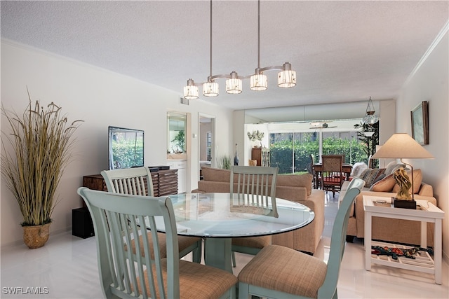 tiled dining room featuring ceiling fan, crown molding, and a textured ceiling