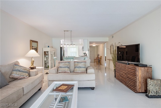 living room featuring a notable chandelier, a textured ceiling, and ornamental molding