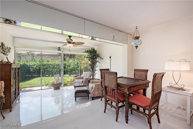 dining area with ceiling fan and a textured ceiling