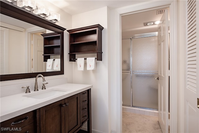 bathroom featuring tile patterned flooring, vanity, and a shower with shower door