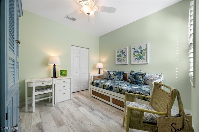 bedroom featuring ceiling fan, light hardwood / wood-style floors, and a closet