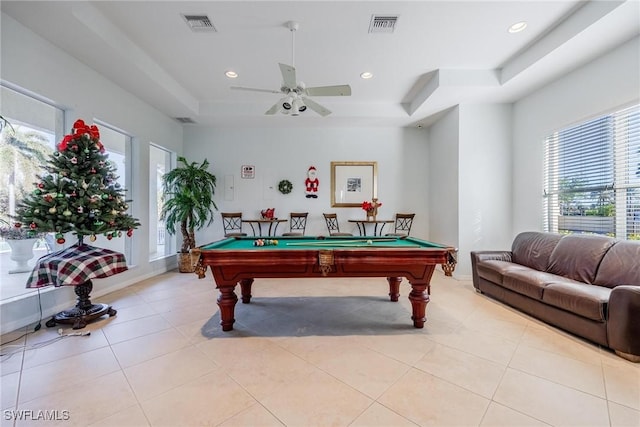 game room with a raised ceiling, light tile patterned flooring, ceiling fan, and billiards