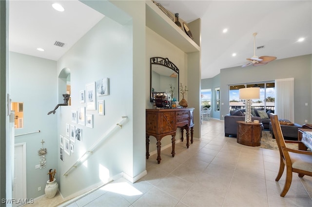 hallway with light tile patterned floors and a high ceiling