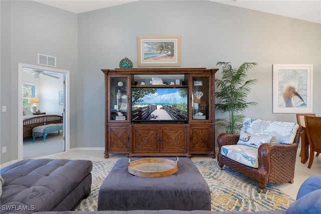 living room with light carpet, ceiling fan, and lofted ceiling