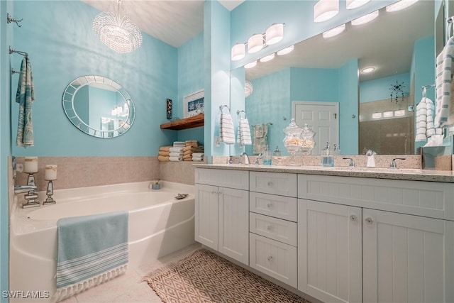 bathroom featuring tile patterned floors, vanity, plus walk in shower, and a chandelier