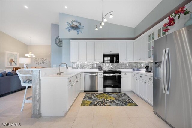 kitchen featuring sink, stainless steel appliances, a kitchen breakfast bar, decorative light fixtures, and white cabinets