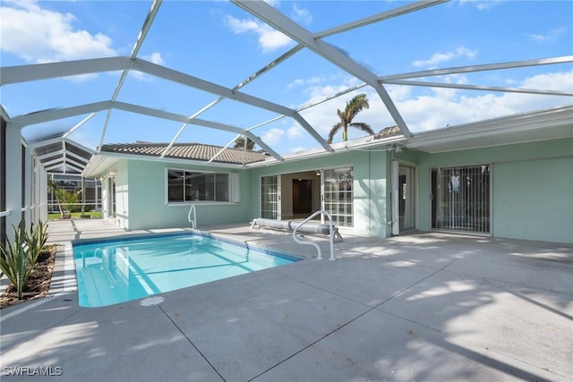 view of swimming pool with glass enclosure and a patio