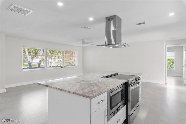 kitchen featuring light stone countertops, extractor fan, white cabinetry, ceiling fan, and stove