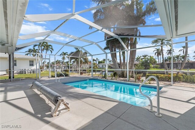 view of swimming pool featuring a patio area and a lanai