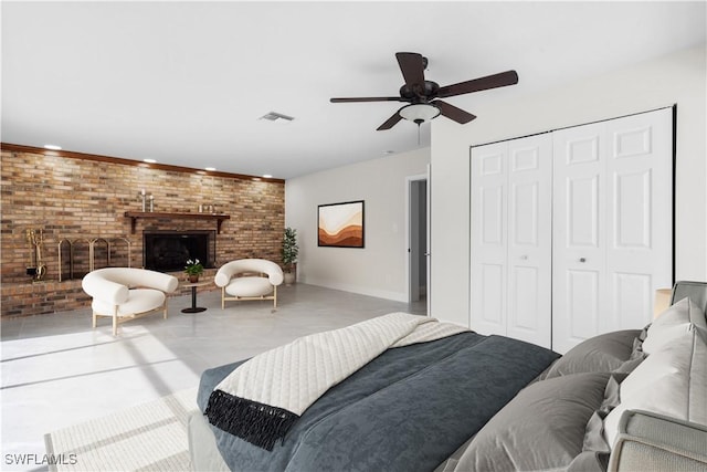 bedroom featuring ceiling fan, brick wall, a closet, and a fireplace