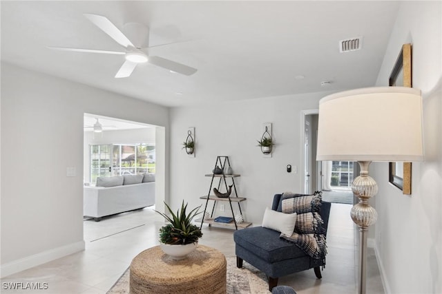 living area with baseboards, visible vents, and ceiling fan