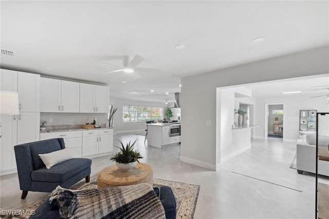 kitchen with white cabinets, a peninsula, light countertops, and a ceiling fan