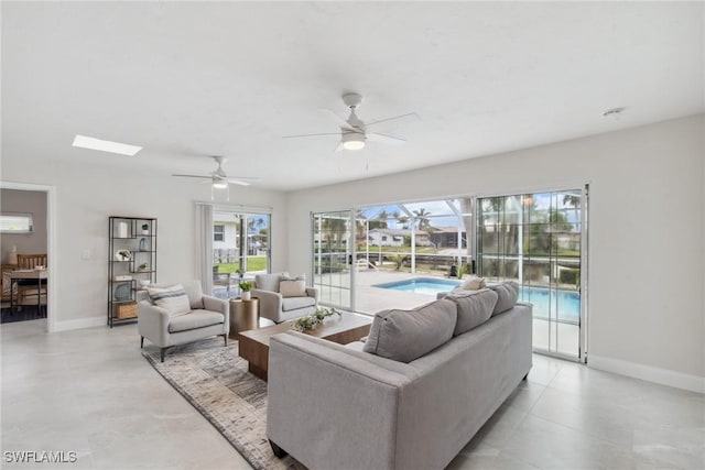 living room with a ceiling fan and baseboards