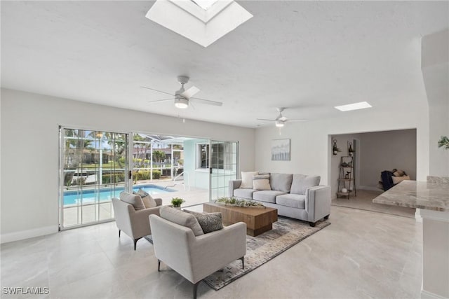 living area with baseboards and a ceiling fan