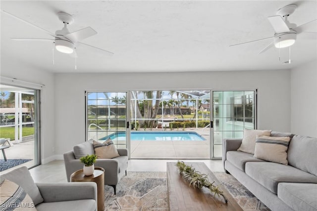 living area featuring a ceiling fan and baseboards