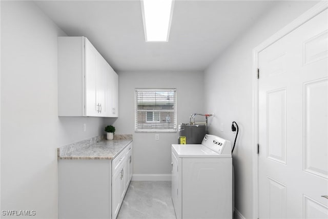 laundry area with washer / dryer, cabinet space, baseboards, and water heater