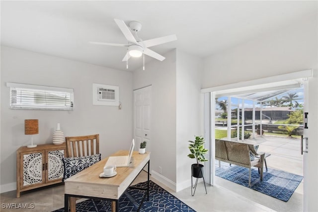 office area featuring a sunroom, ceiling fan, baseboards, and a wall mounted AC