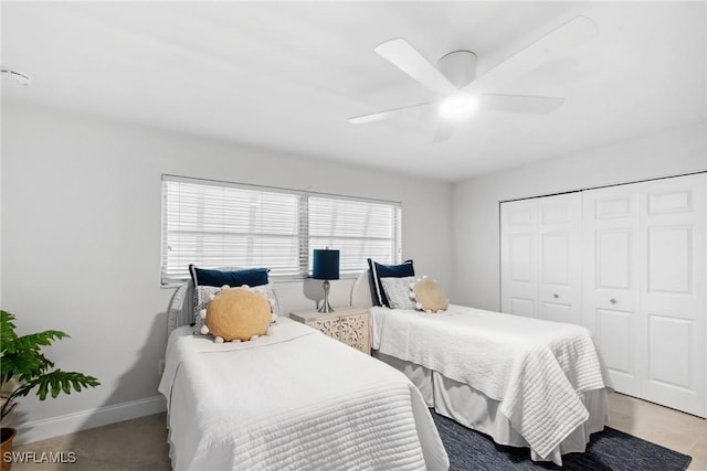 bedroom featuring ceiling fan, baseboards, and a closet