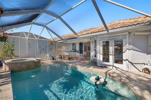 view of pool with glass enclosure, an in ground hot tub, a patio, and french doors