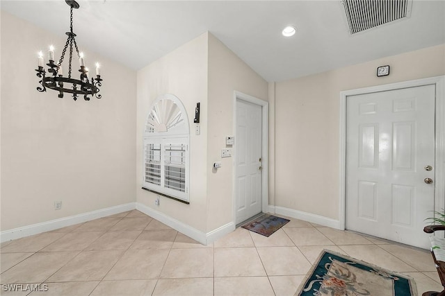 tiled foyer entrance with a chandelier and vaulted ceiling