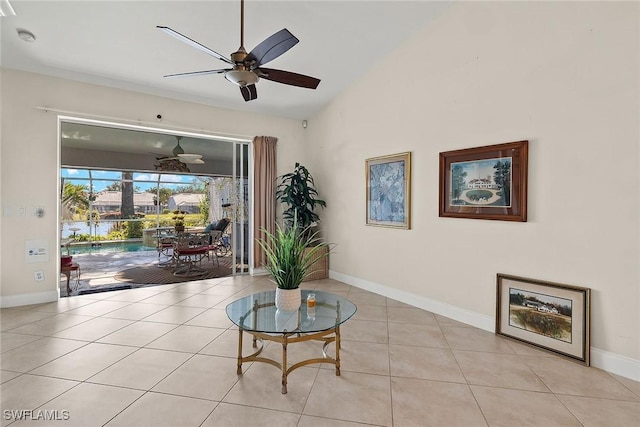 living area featuring ceiling fan, light tile patterned floors, and lofted ceiling