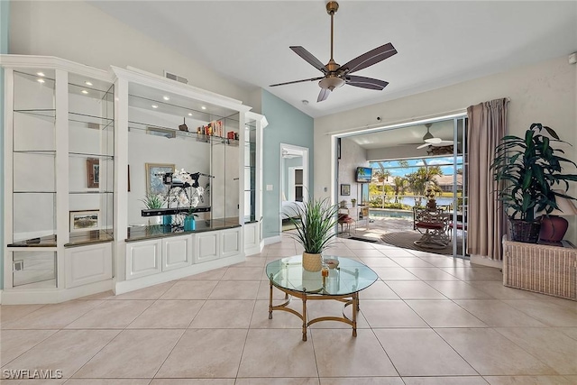 tiled living room with ceiling fan and lofted ceiling