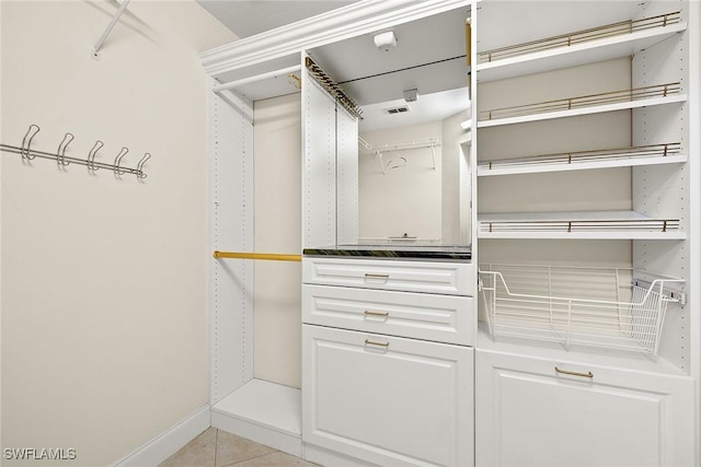 walk in closet with light tile patterned floors