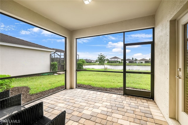 unfurnished sunroom featuring a water view