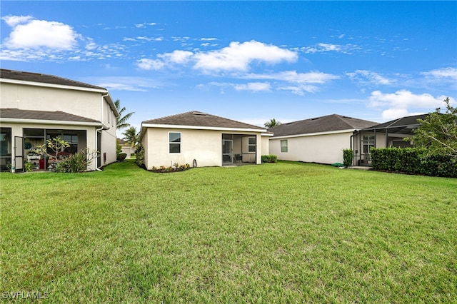 back of property featuring a lanai, a yard, and a sunroom