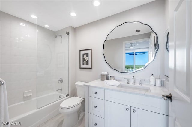 full bathroom featuring tiled shower / bath, vanity, and toilet