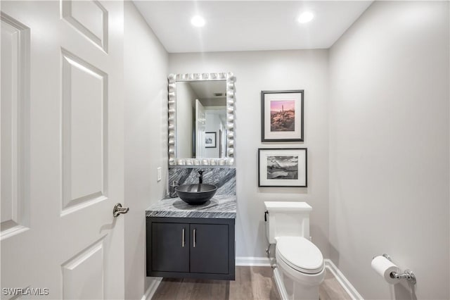 bathroom with vanity, toilet, and wood-type flooring